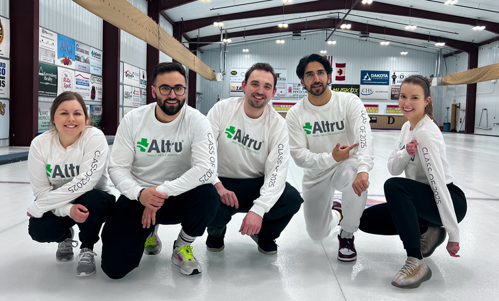 5 Altru residents posing on the ice at the curling club.