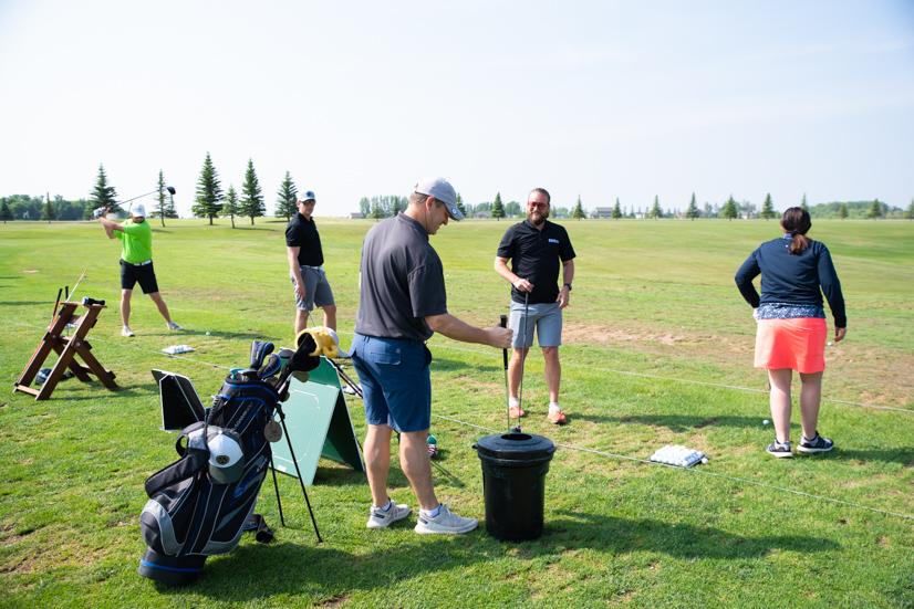 A row of golfers at the practice range before the Annual Altru Foundation Golf Tournament.